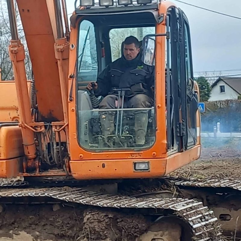 Ouvrier dans une cabine d'excavatrice effectuant des travaux de terrassement